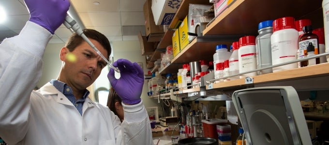 man using pipet in lab 