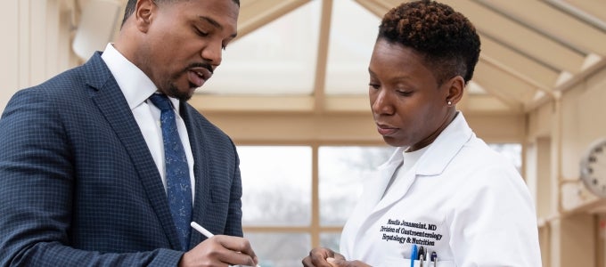 female doctor and man signing paperwork